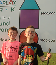 Picture of Jude and Beau in front of the donor status sign at the Park location.